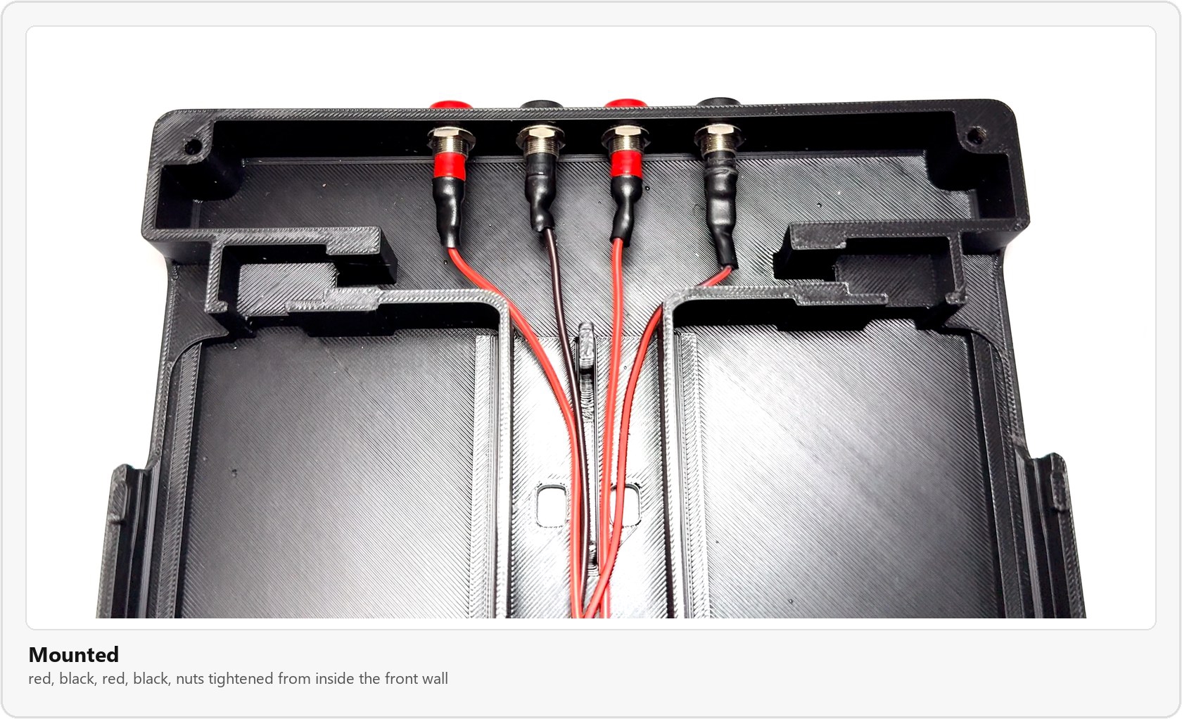 The four banana jacks mounted in the front wall, red, black, red, black, with heat shrink over the joints and the wires running back toward the center channel