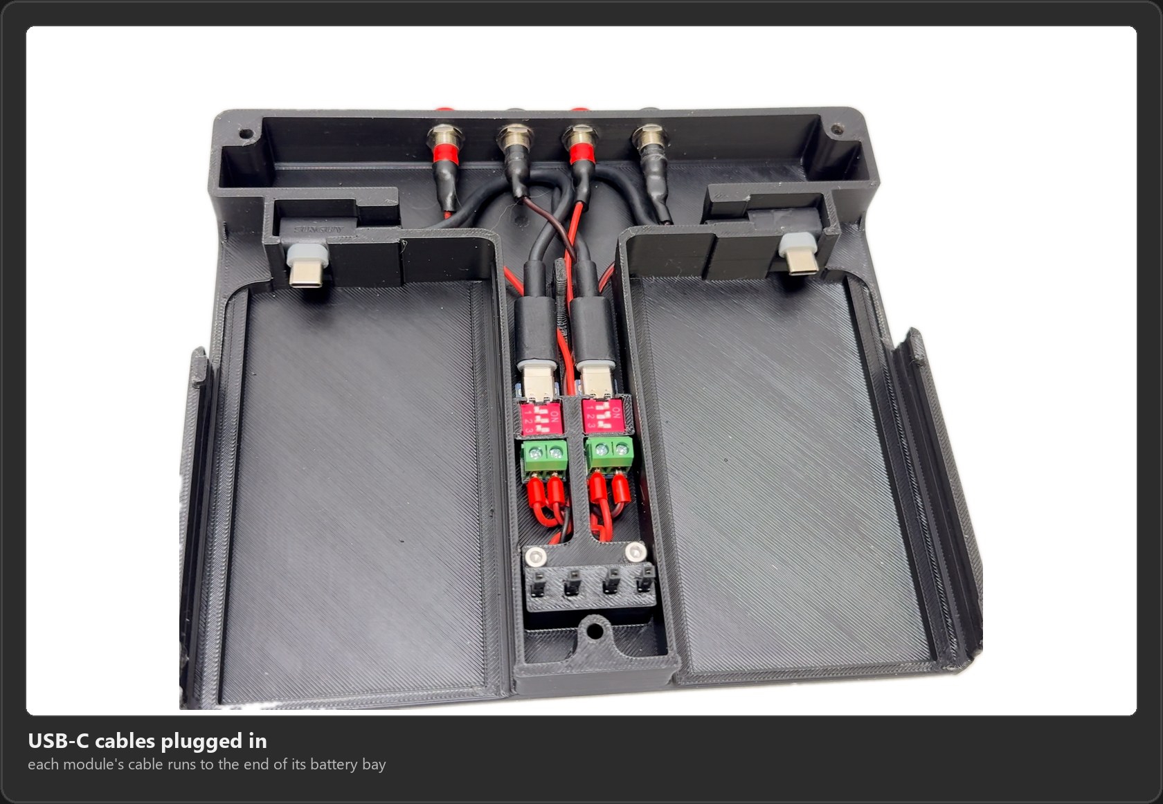 The base with a USB-C cable plugged into each PD module and its plug sitting at the end of each battery bay
