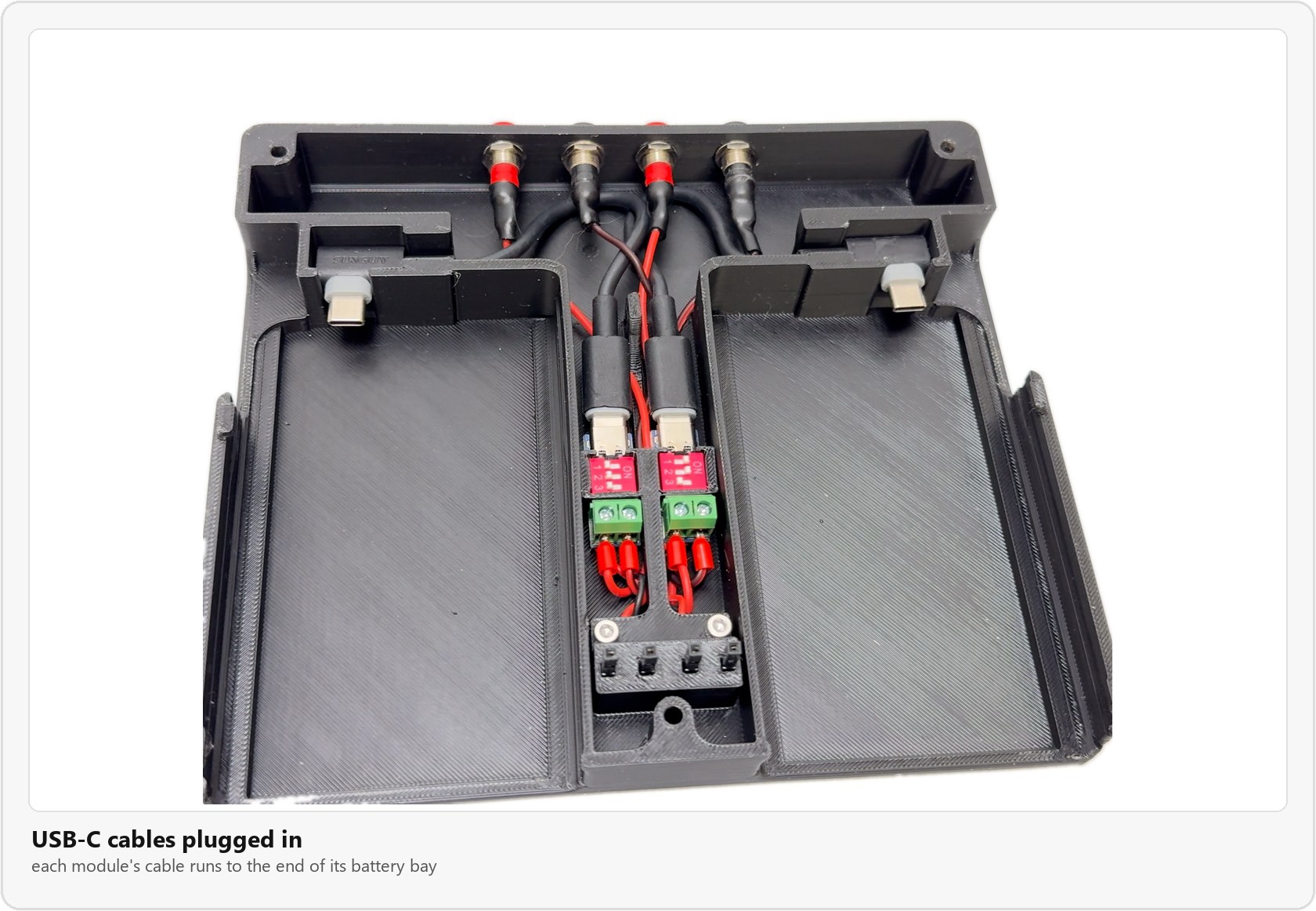 The base with a USB-C cable plugged into each PD module and its plug sitting at the end of each battery bay