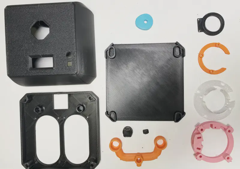 Collection of FDM printed internal components and base parts laid out before assembly